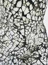 Close-up of hand-painted silver mosaic glass texture on a handcrafted bust lamp.
