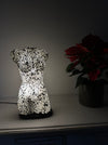 Silver mosaic torso lamp creating ambient glow on a table