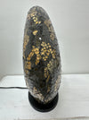 Angled side view of handmade black and gold mosaic donut lamp showing its curved shape and detailed glass craftsmanship