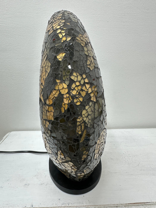 Angled side view of handmade black and gold mosaic donut lamp showing its curved shape and detailed glass craftsmanship