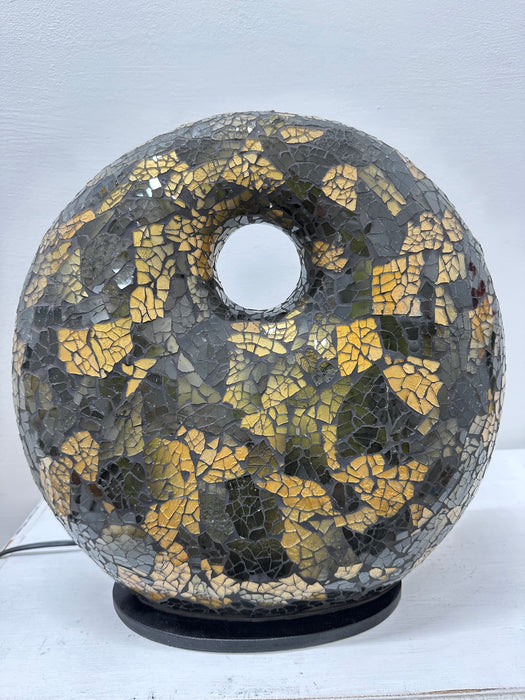 Handmade mosaic donut lamp in black and gold, shown turned off to display the intricate glass pattern and texture.