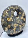 Side view of handmade black and gold mosaic donut lamp showing the curved fiberglass-reinforced base and detailed glass tile pattern