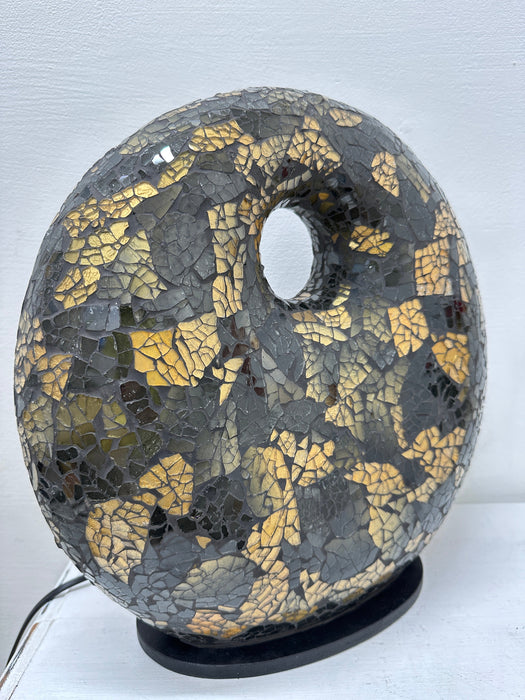 Side view of handmade black and gold mosaic donut lamp showing the curved fiberglass-reinforced base and detailed glass tile pattern