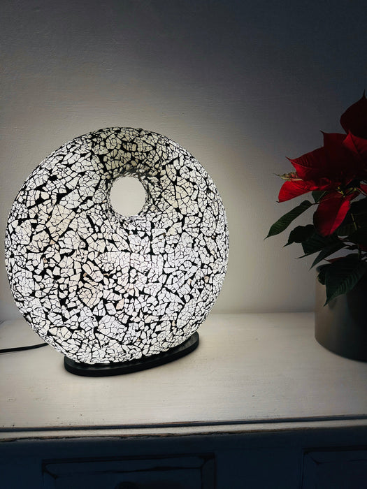 Silver mosaic donut lamp glowing in low light setting