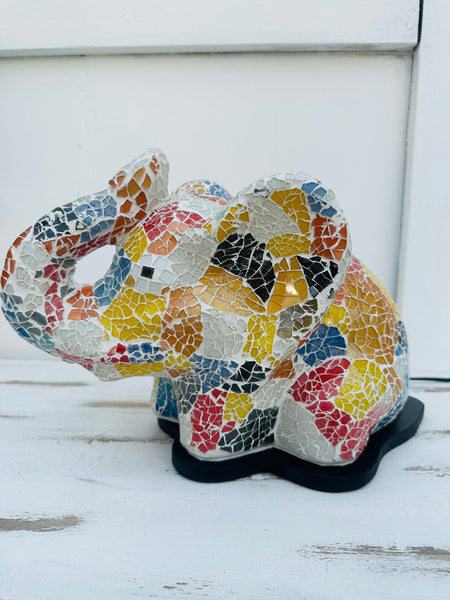 Handmade mosaic elephant lamp switched off on white background, showing multicoloured glass pattern and black base.
