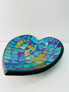 op view of handmade mosaic heart bowl showing vibrant cyan, turquoise and green glass mosaic pieces on black rim.