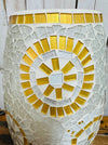 Close-up of mosaic lamp top showing intricate white and gold sunburst glass pattern on handcrafted surface.