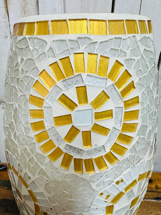 Close-up of mosaic lamp top showing intricate white and gold sunburst glass pattern on handcrafted surface.