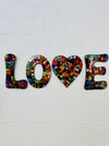 front view of mosaic 'love' letters on white background