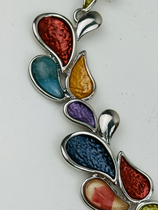Close-up of colourful teardrop-shaped enamel necklace with silver-tone chain, largest drop in the centre measures 2cm.