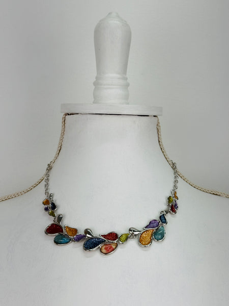 Multicoloured teardrop shaped enamel statement necklace with silver-tone chain, displayed on a mannequin.