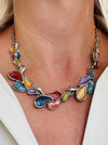 Multicoloured teardrop shaped enamel statement necklace with silver-tone chain, displayed on a model.