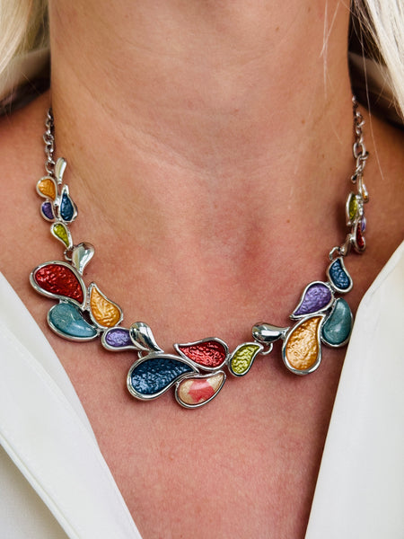 Multicoloured teardrop shaped enamel statement necklace with silver-tone chain, displayed on a model.