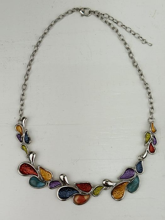 Multicoloured teardrop shaped enamel statement necklace with silver-tone chain, displayed on a table.