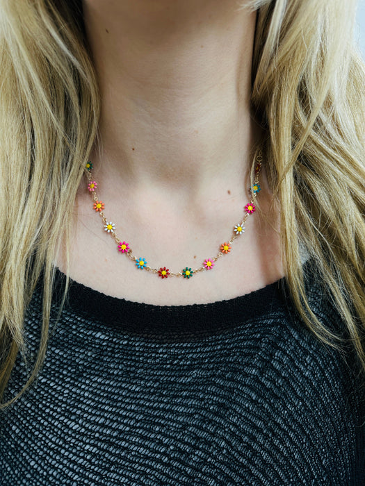 delicate necklace with small multicolour enamel flower charms on a fine chain on a model