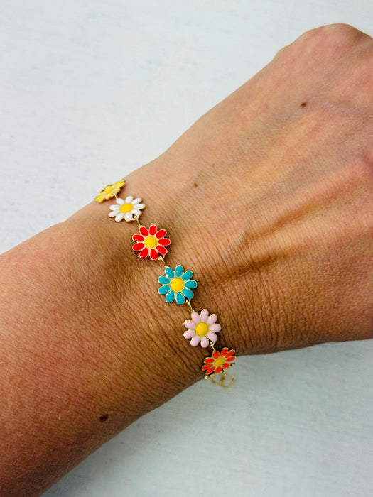 Colorful flower bracelet on a wrist against a light background