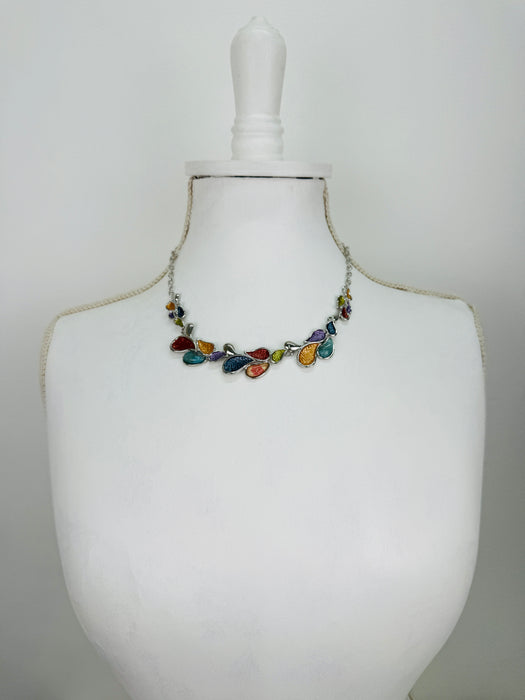 Multicoloured teardrop shaped enamel statement necklace with silver-tone chain, displayed on a mannequin.