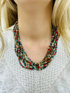 Multistrand beaded necklace with natural wooden button clasp in earthy multicolor tones.
