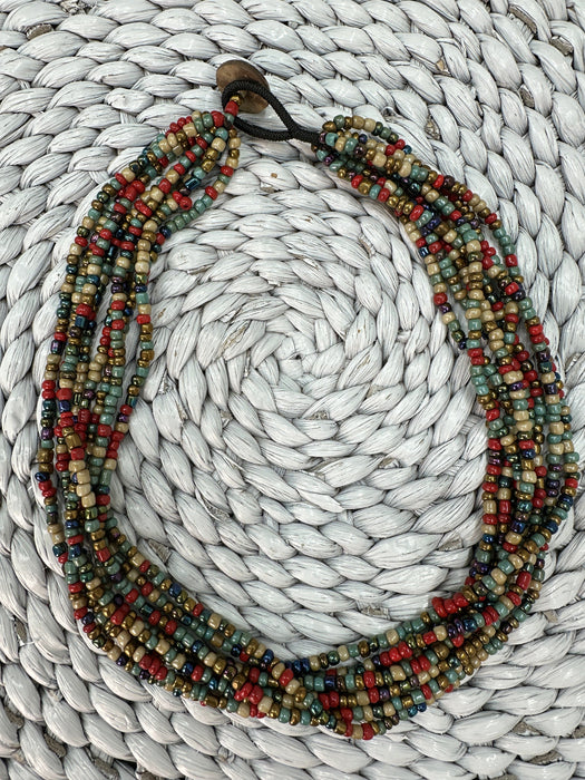 Multicolored beaded necklace on a textured white surface
