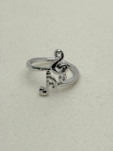 Silver ring with musical note design on a light gray background