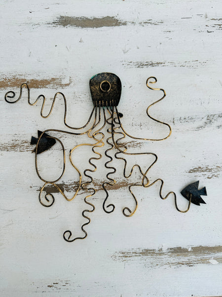 Back of green octopus metal wall art showing hanging eyelet and metal structure