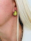 Olive green teardrop enamel stud earrings with silver tone, displayed on a model.