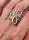Simple silver open petal flower ring with gold centre, displayed on a model.
