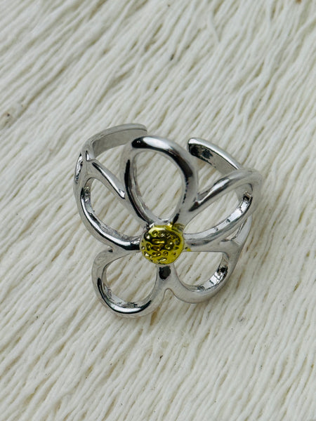 Simple silver open petal flower ring with gold centre, displayed on a white background.
