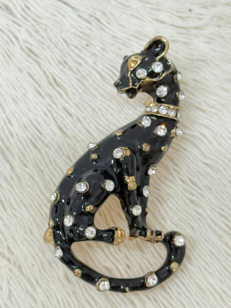 Black enamel panther brooch with gold-tone finish and crystal details.