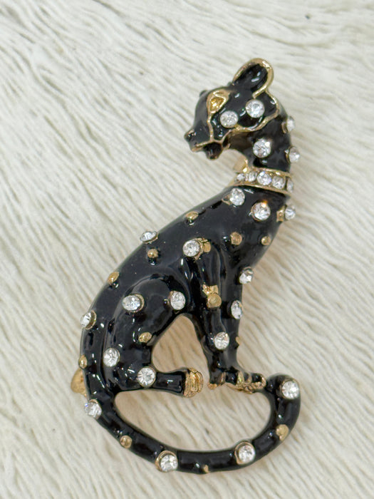Black enamel panther brooch with gold-tone finish and crystal details.