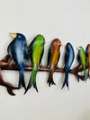 Close-up view of hand-painted metal parakeets in blue, green and copper tones