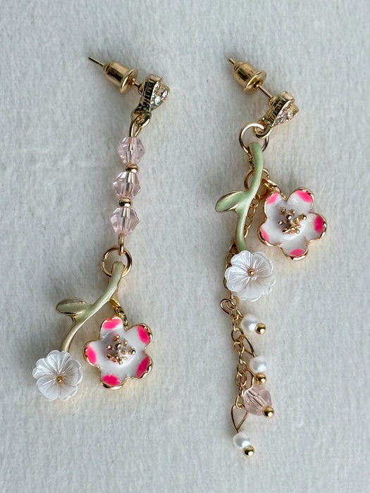 Floral earrings with pink and white flowers on a light gray background