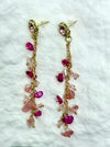 Pair of earrings with pink gemstones on a white textured background