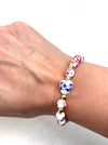 Bracelet with floral beads on a wrist against a white background