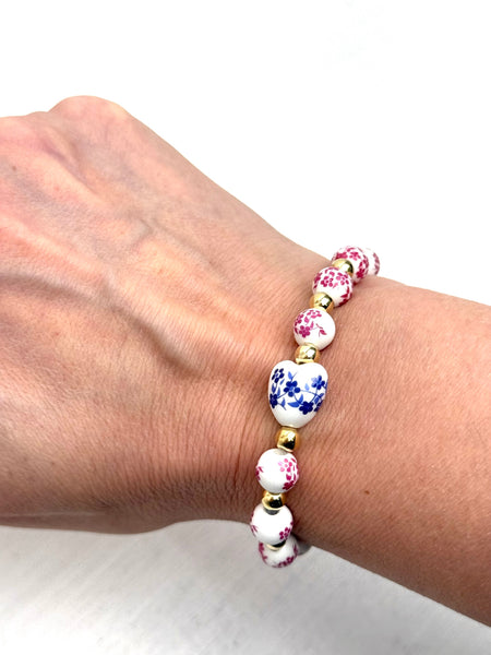 Bracelet with floral beads on a wrist against a white background