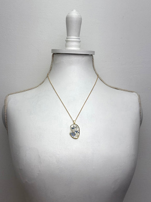 gold necklace with floral face silhouette pendant