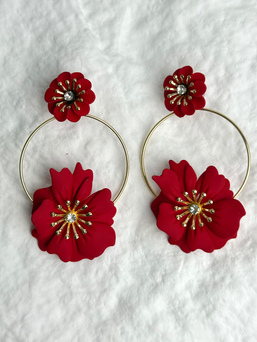 Red floral hoop earrings on a textured white background