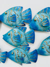 Close-up of hand-painted recycled metal reef fish in blue tones.
