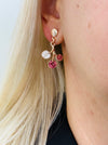 Rose-gold floral enamel drop earrings with gold tone finish, displayed on a model.