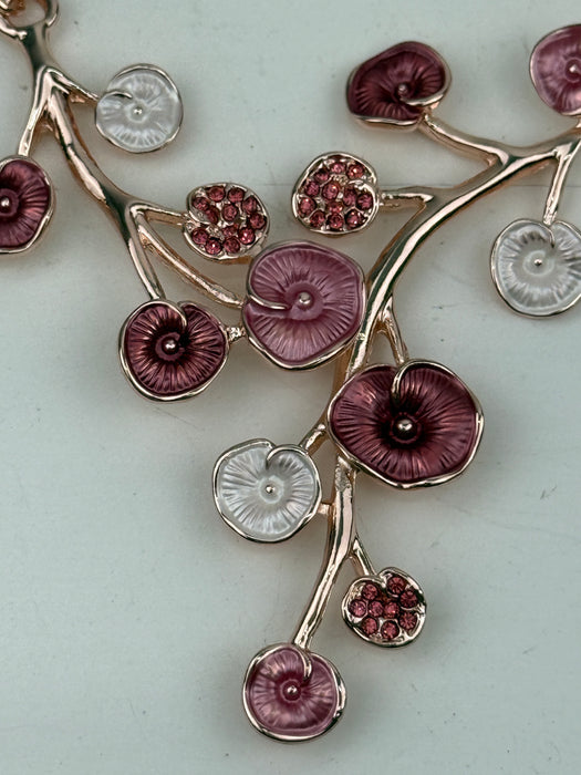 Close-up of rose gold floral enamel necklace with gold-tone chain.