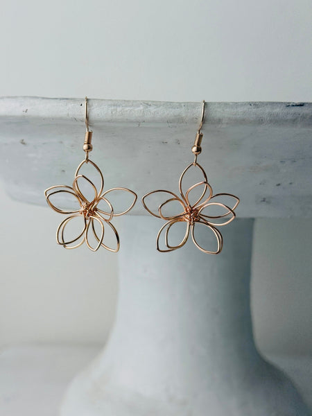 close-up of delicate flower wire earrings