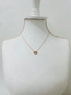rose gold necklace with a heart pendant on a mannequin bust against a white background