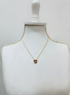 Gold necklace with a heart pendant on a mannequin bust against a white background