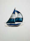 Close-up of blue and silver metal sailing boat wall art showing hand-painted metallic details