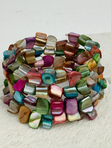 An artful combination of multi coloured shell set on flexible wire, displayed on a white background.