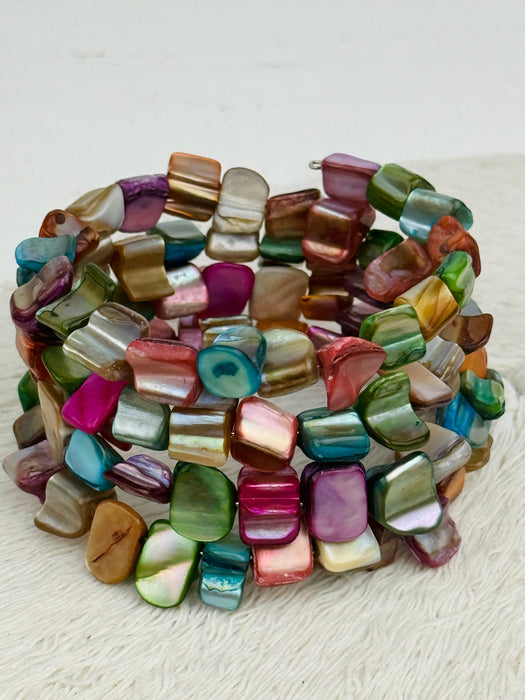 An artful combination of multi coloured shell set on flexible wire, displayed on a white background.