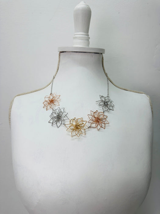 Necklace with floral designs on a mannequin bust 