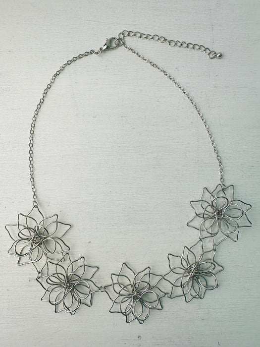 front of short silver flower link necklace