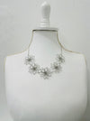 short silver flower link necklace displayed on a mannequin