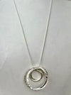 Silver necklace with a circular pendant on a light gray background
